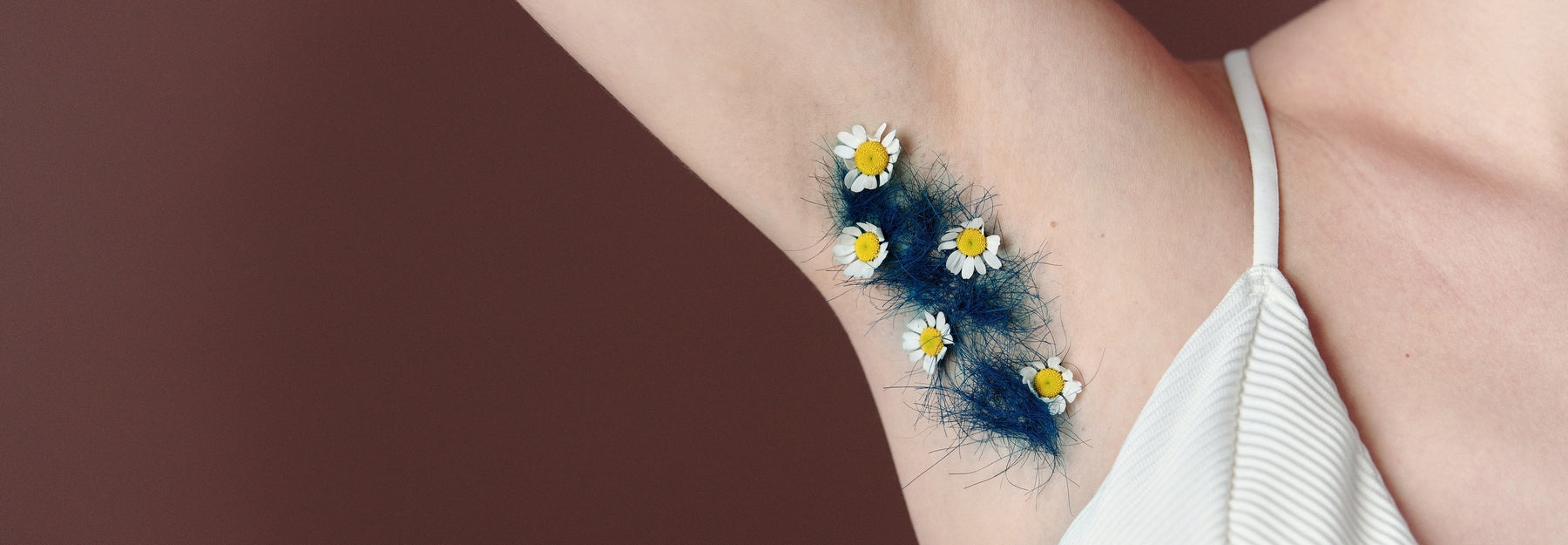 Photo of armpit with blue hair and daisies