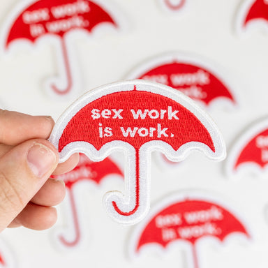 The sex work is work umbrella patch with others on a table in the background