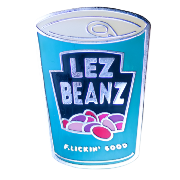 An enamel pin that is shaped like a can of beans. The logo on the can says Lez Beans, and an illustration of baked beans sits under the text. At the bottom of the can are the words "Flickin' good"