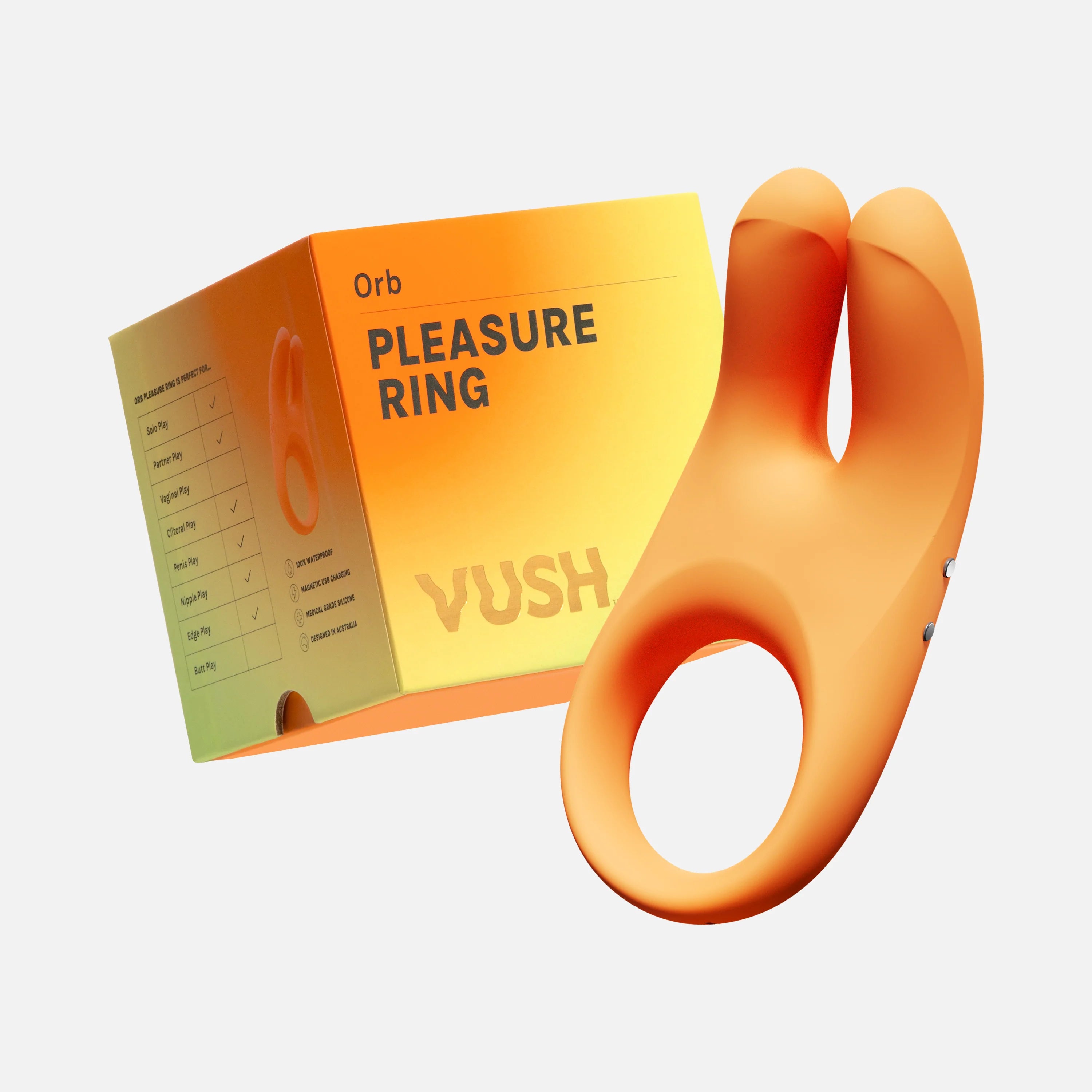 An orange cock ring with Rabbit-style ears on the top is in the foreground, and its orange box that says "Pleasure Ring, Vush" is in the background. 