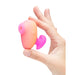 The Romp Kiss held between a thumb and index finger, showing how compact it is. The romp kiss is orange and pink ombré colours. 