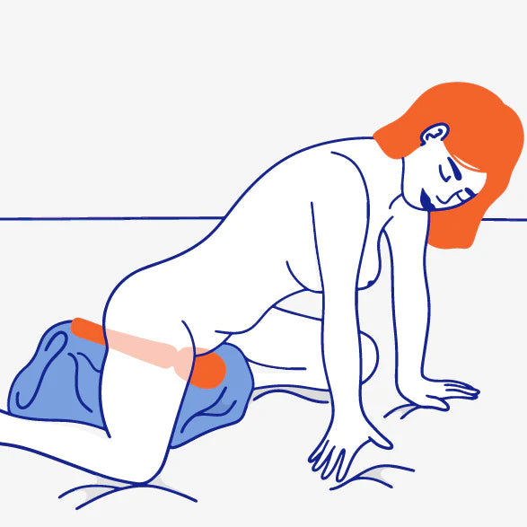 An illustration of a person with long orange hair on their hands and knees sitting on the head of the wand. The wand is on top of a pillow to support it closer to the person's body. 