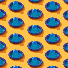 Blue condoms lined up on an orange background