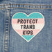 A heart with the trans flag colours and text that reads "Protect Trans Kids"
