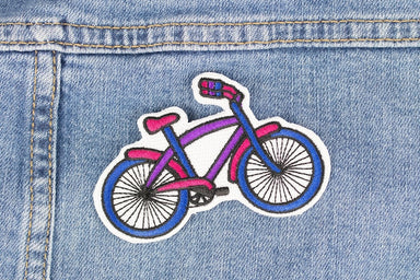 A patch that features a bike in the proud colours of the bisexual pride flag.