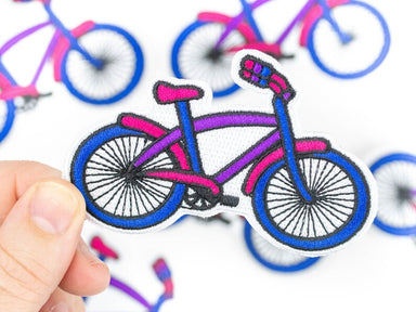 The bicycle patch being held in front of other bicycle patches.