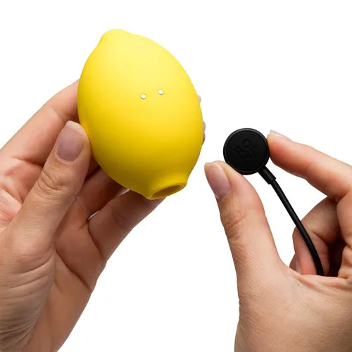 Yellow lemon-shaped toy pictured with its magnetic charger against a white background.