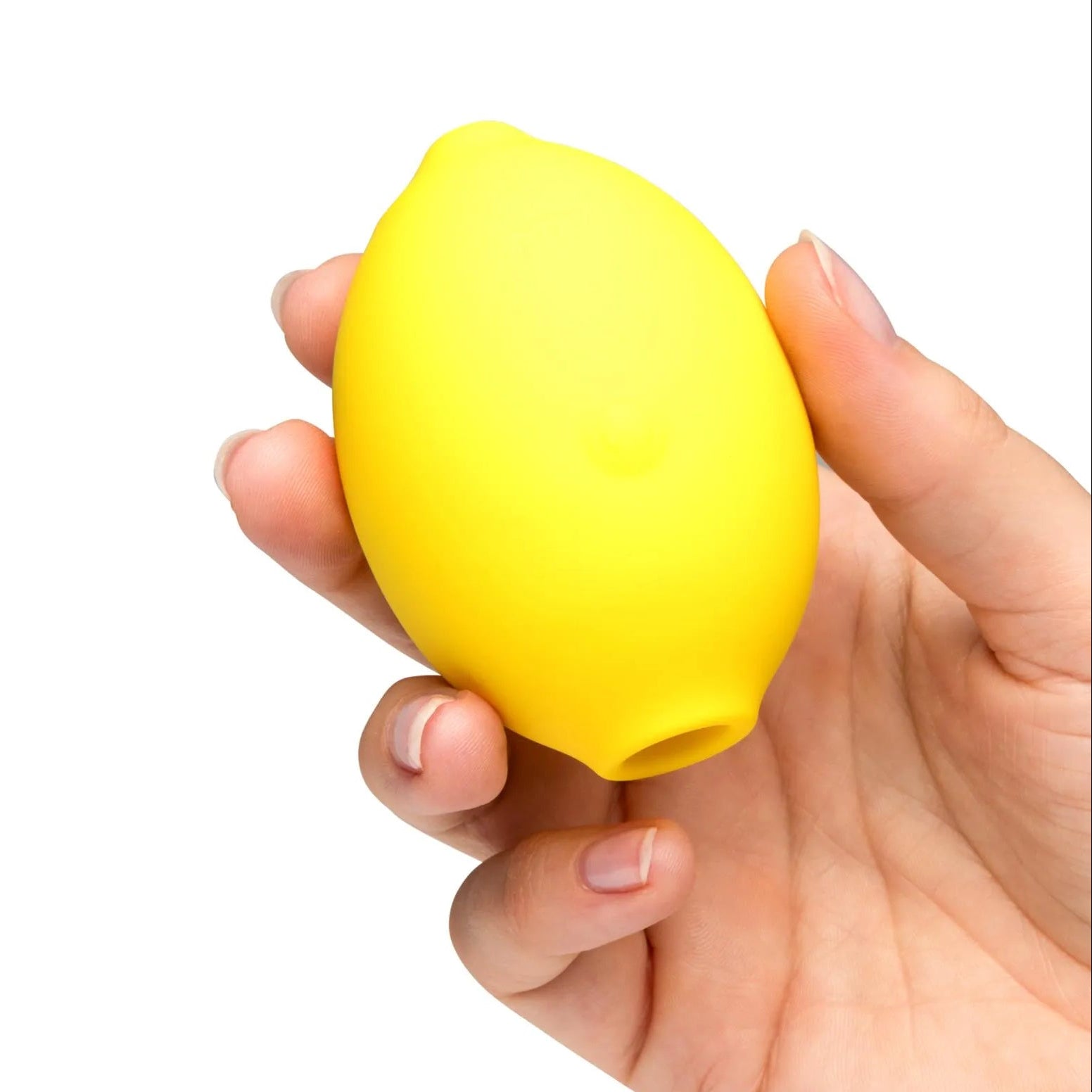Hand holding a yellow lemon-shaped toy against a white background