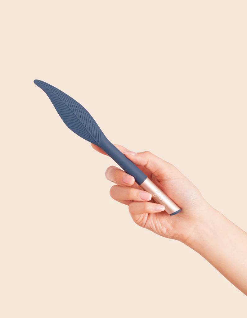 Blue feather vibrator being held in hand upright
