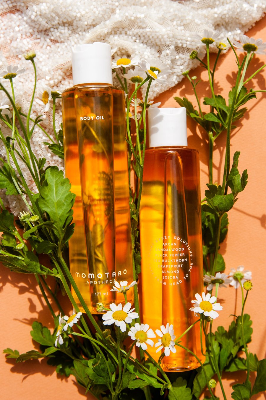 Two bottles of body oil with dandelions