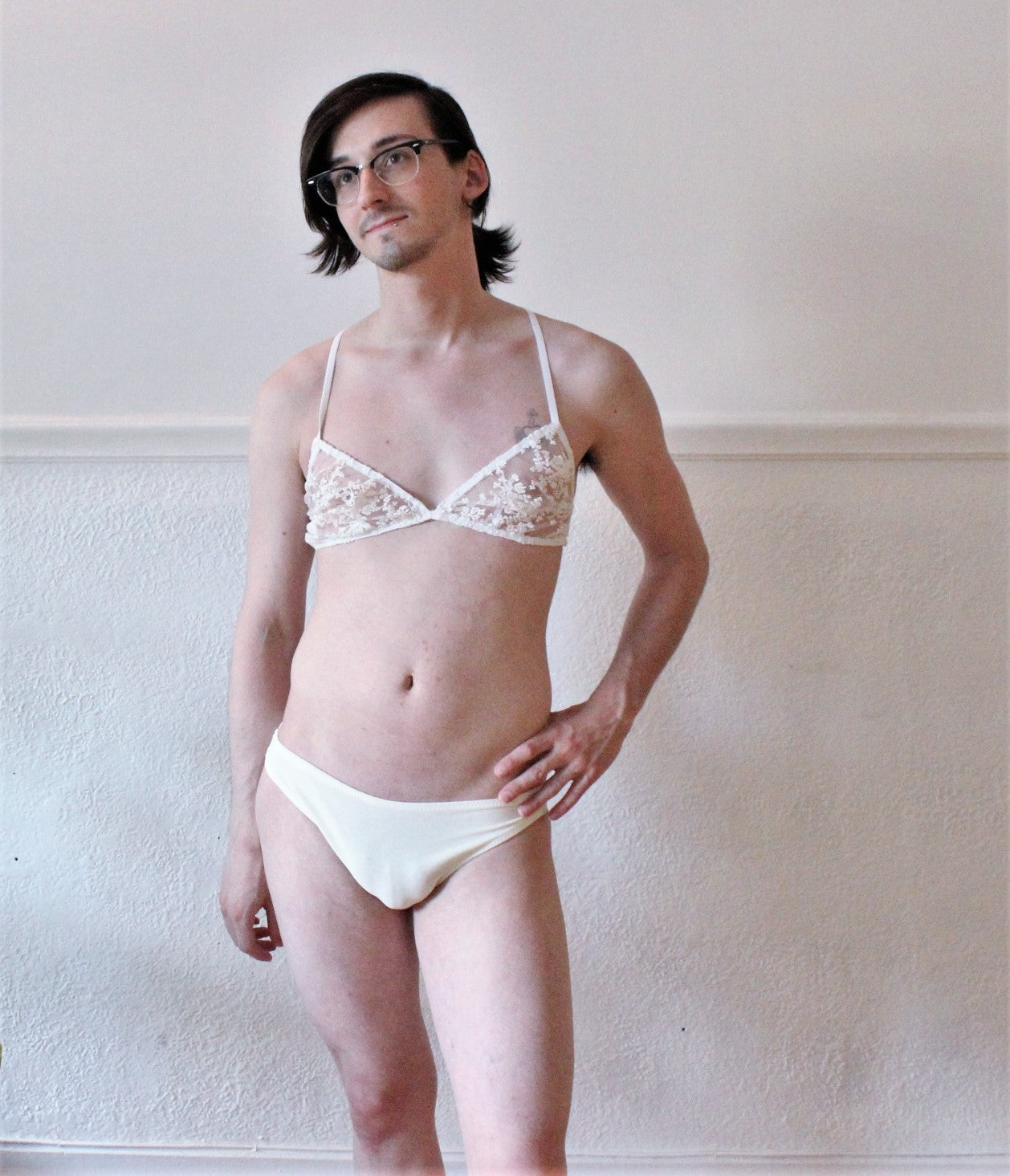Person standing front on, wearing white thong underwear and bra