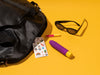 Romp sex toy on a yellow background, near sunglasses and a purse
