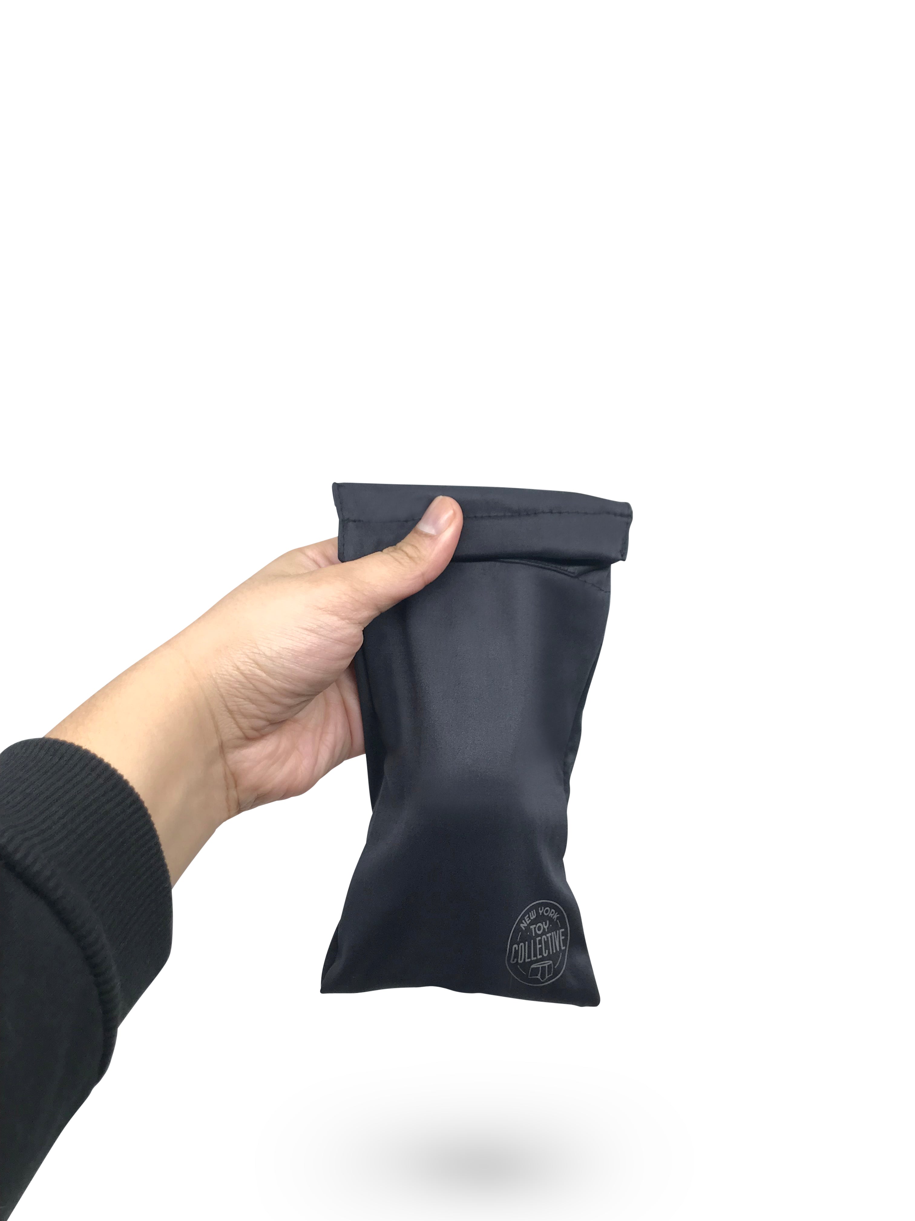 Black packing pouch with packer inside, being held by a hand