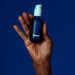 Dame sex oil being held by a hand on blue background