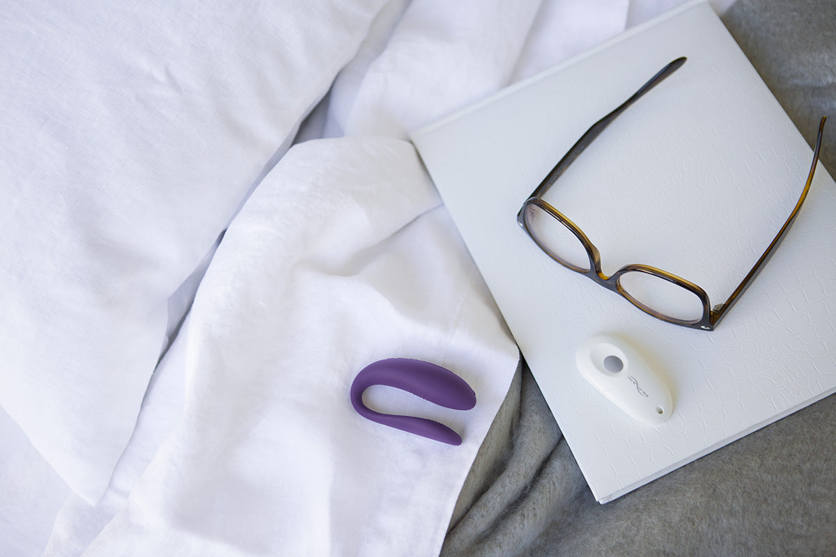 We-Vibe Unite on bed with glasses